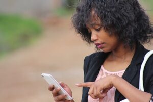 Woman standing outside looking at her phone