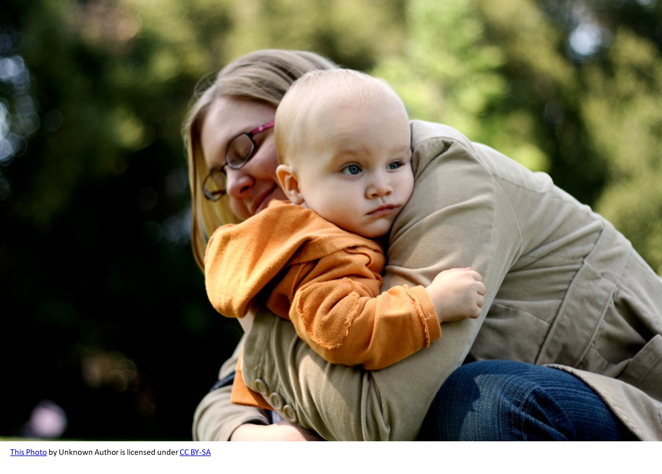 Mom leaning down and hugging toddler tight